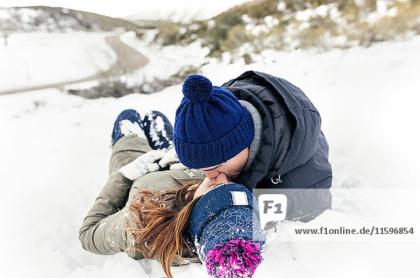 Junges Paar beim Küssen im Schnee