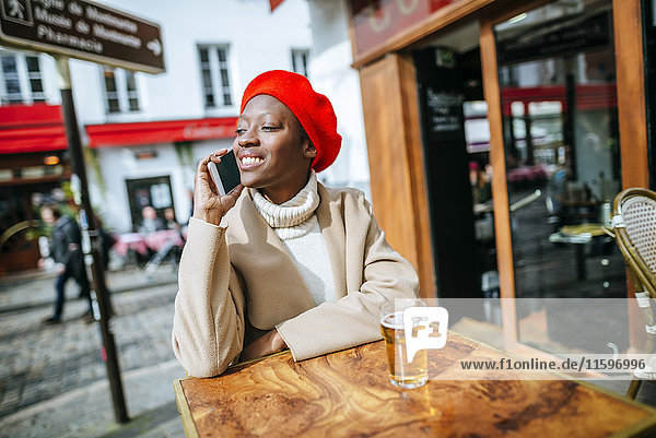 Young woman in Paris sitting in cafe and talking on the phone