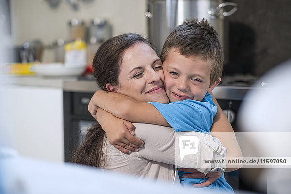 Mother and son hugging in kitchen