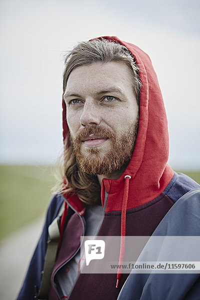 Portrait of confident man wearing hoodie outdoors