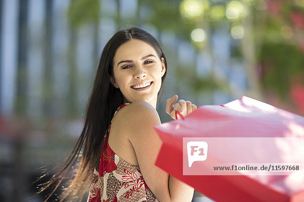 Portrait of happy young woman with shopping bags