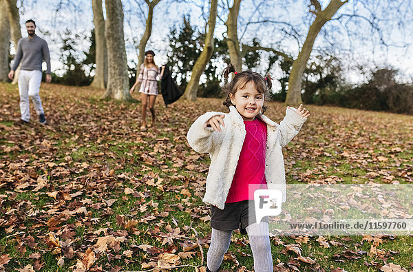 Portrait of happy little girl running on a hill in autumn