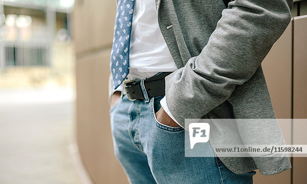 Businessman with hands in pockets  mid section