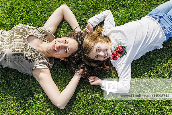 Mutter und Tochter haben Spaß beim Liegen im Gras