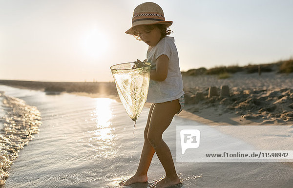 Spanien  Menorca  kleines Mädchen mit Tauchnetz am Strand