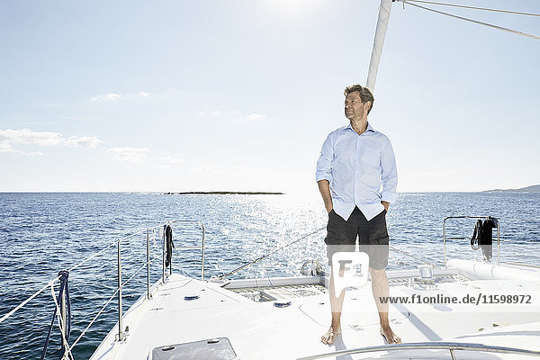 Erwachsener Mann auf einem Segelboot stehend