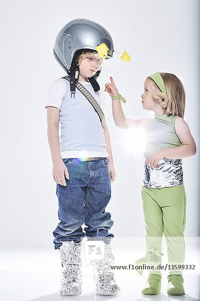 Mädchen verkleidet als Alien  das in Kontakt mit einem Jungen kommt  der als Raumfahrer verkleidet ist.
