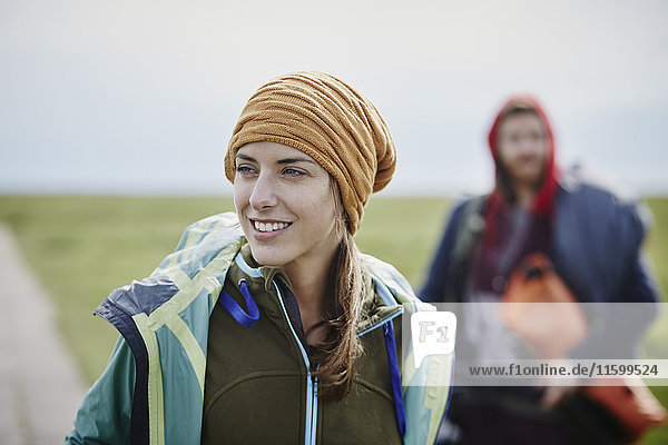 Smiling woman with man in background on a trip