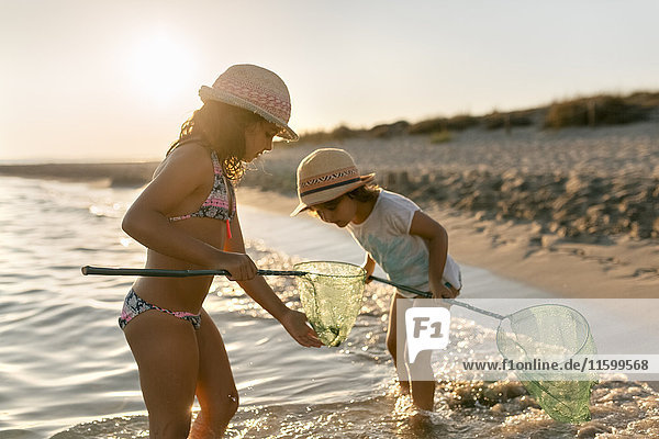 Spanien  Menorca  zwei Mädchen mit Dip-Netzen am Strand