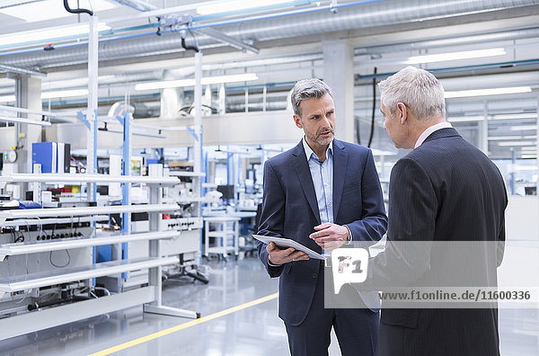 Two mangagers having a meeting at the shop floor of a factory