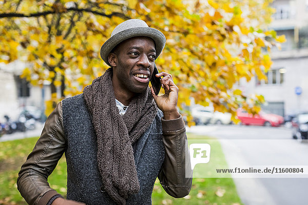 Porträt eines stilvollen Mannes am Telefon im Herbst