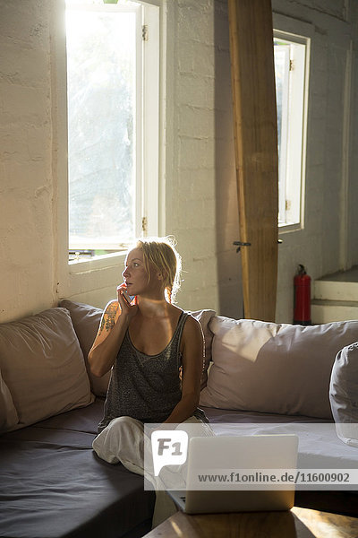 Blond woman on the phone sitting on the couch