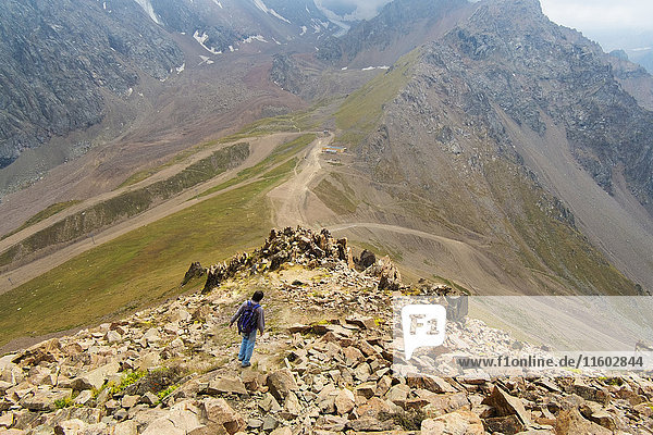 Kaukasischer Mann beim Wandern auf Bergfelsen