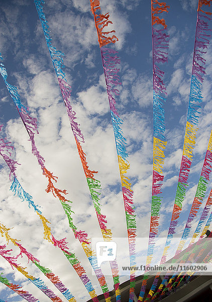 Multicolor flags blowing in wind under blue sky