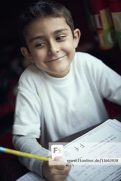 Proud Hispanic boy practicing writing alphabet