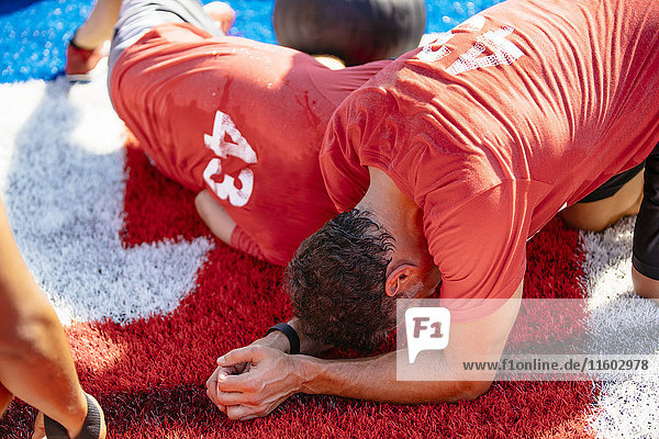 Fatigued men resting on artificial turf field