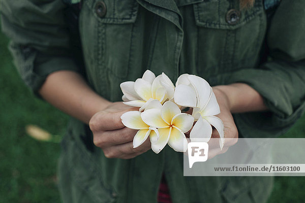 Die Hände einer kaukasischen Frau halten Blumen