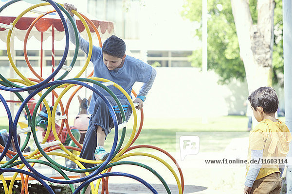 Hispanic boys climbing on structure at playground