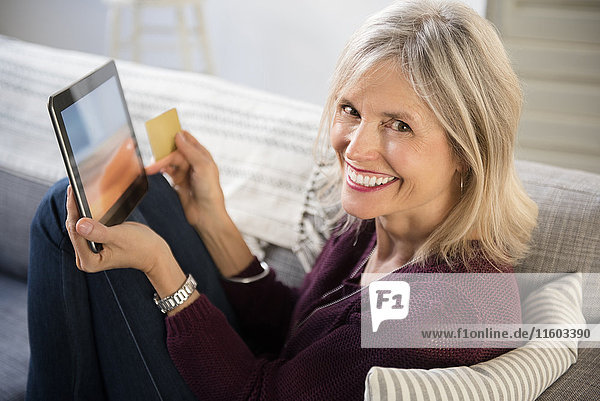 Lächelnde kaukasische Frau beim Online-Shopping mit digitalem Tablet