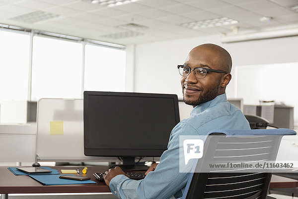 Smiling African American man using computer in office