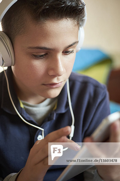 Hispanischer Junge mit digitalem Tablet und Kopfhörern