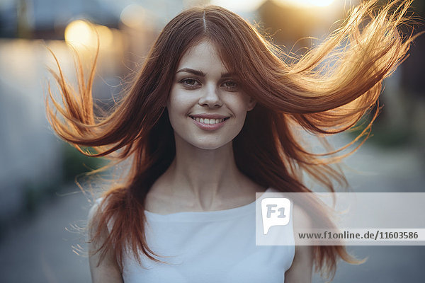 Wind blowing hair of smiling Caucasian woman
