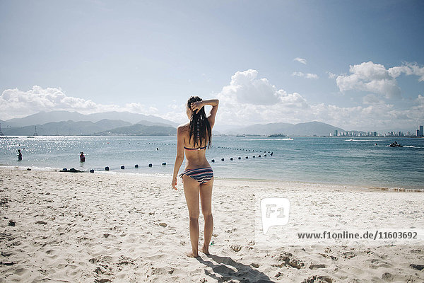 Kaukasische Frau trägt Bikini am Strand