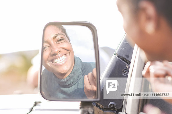 Reflexion einer afroamerikanischen Frau im Autospiegel