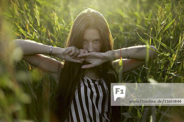 Caucasian woman covering mouth with hands in field