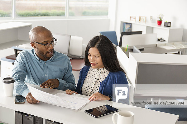 Man and woman reading paperwork in office
