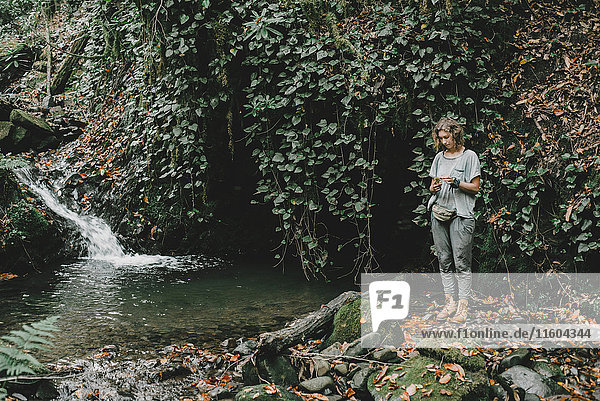 Caucasian woman standing near forest stream