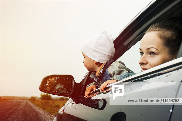 Kaukasische Mutter und Sohn schauen aus dem Autofenster