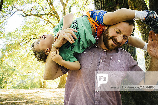 Kaukasischer Vater spielt mit seinem Sohn auf der Schulter