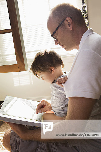 Father reading book to son in lap