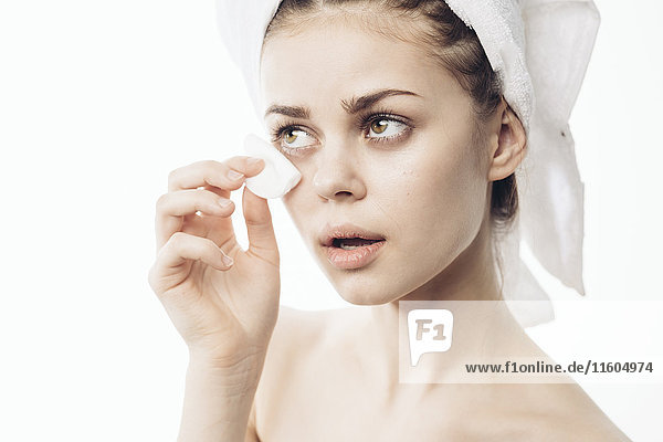 Caucasian woman cleaning eye with pad