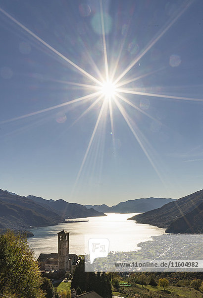 Sun in blue sky over Gravedona Lake Como Italy