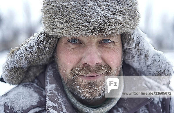 Porträt eines kaukasischen Mannes mit Eis im Bären im Winter