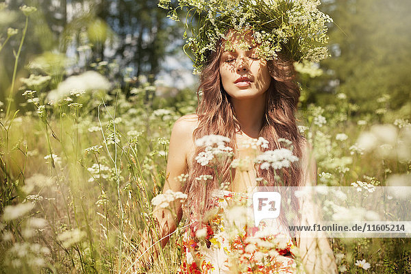 Caucasian woman enjoying wildflowers in field