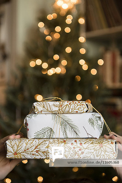 Hands of Caucasian woman holding Christmas gifts