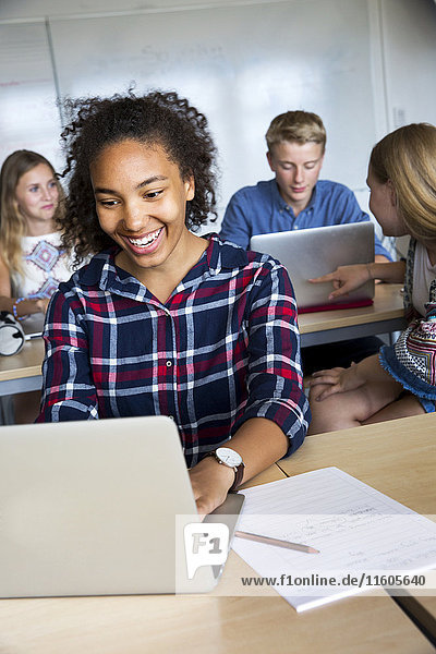 Teenager mit Laptop im Klassenzimmer