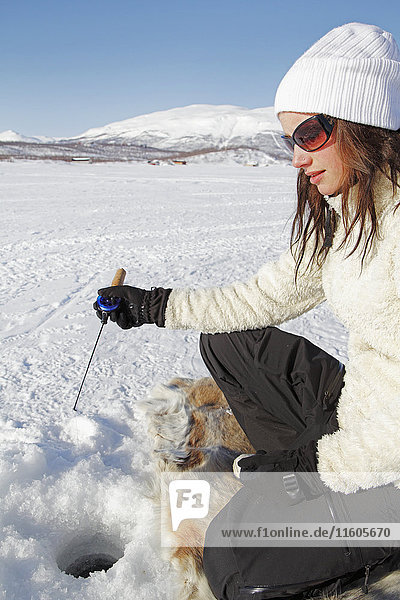 Young woman ice fishing