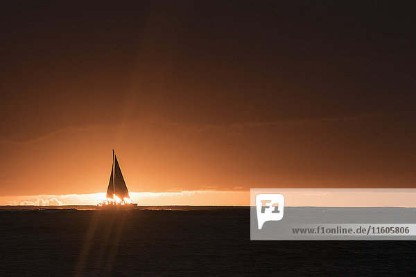 Silhouette der Yacht im Meer gegen den Himmel bei Sonnenuntergang