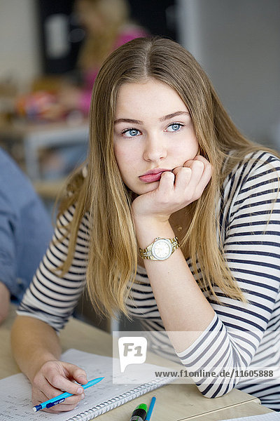 Portrait of bored teenage girl in classroom