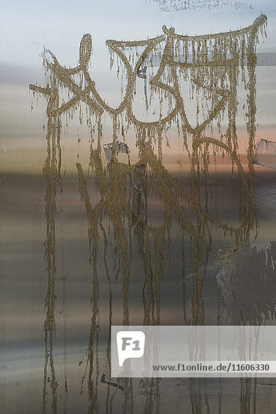 Nahaufnahme von Graffiti auf Metall bei Sonnenuntergang