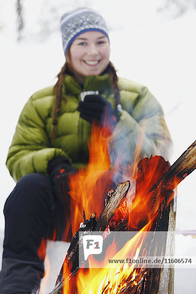 Smiling woman by fireplace