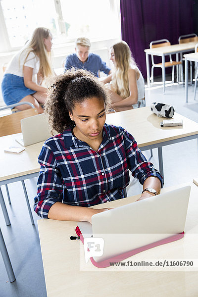 Teenager mit Laptop im Klassenzimmer