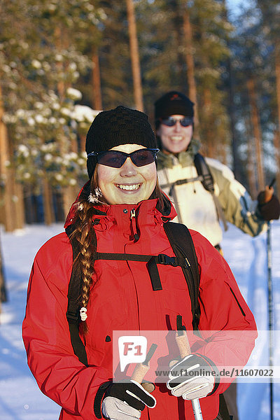 Porträt einer lächelnden Frau im roten Wintermantel