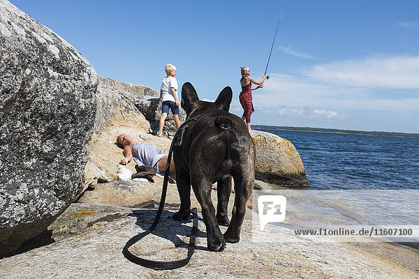 Familie verbringt Zeit am Meer mit Hund
