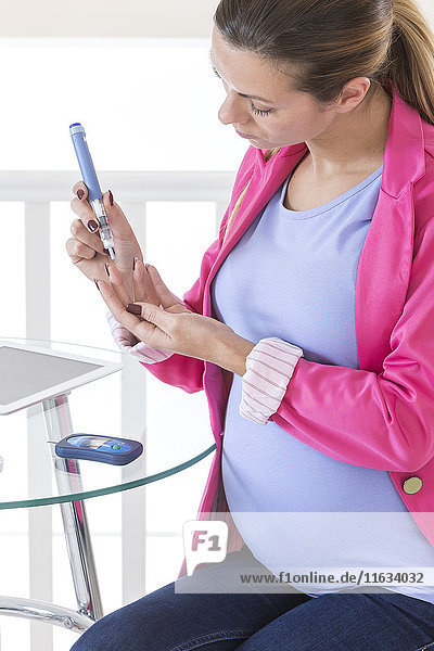 Schwangere Frau bei der Kontrolle ihres Blutzuckerspiegels.