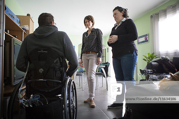 Reportage über einen häuslichen Pflegedienst in Savoie  Frankreich. Eine Krankenschwester und eine Hilfsschwester unterhalten sich mit einem Patienten.
